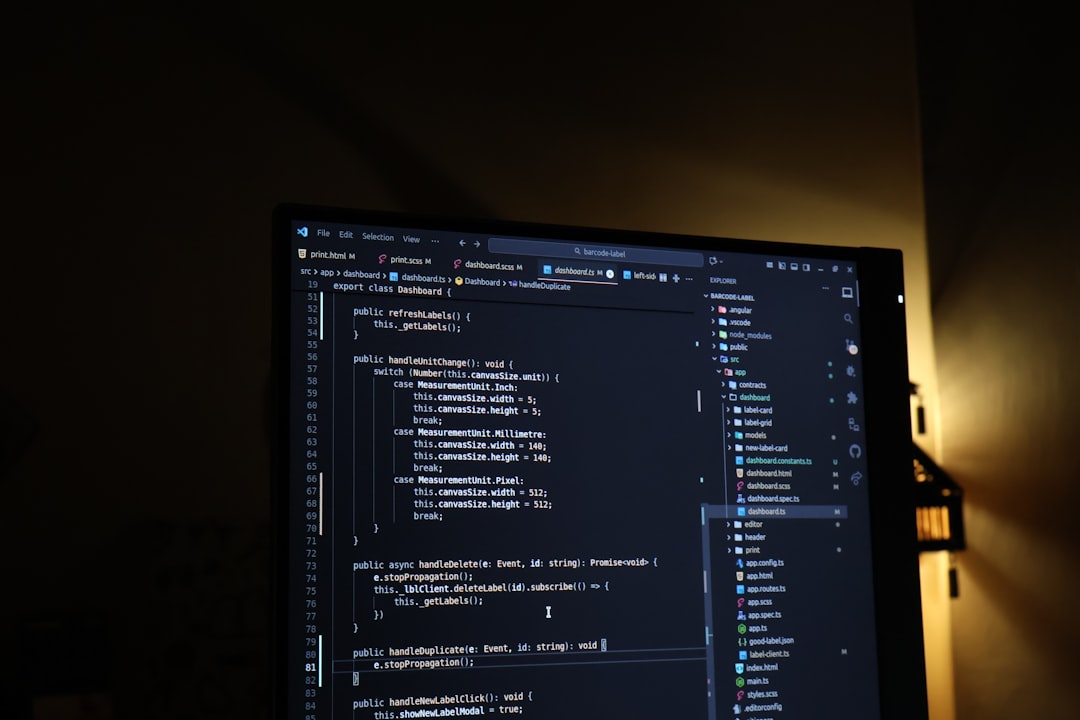 TypeScript programming code - A computer monitor having source code on the screen with dark mode editor and a warm yellow light in the background